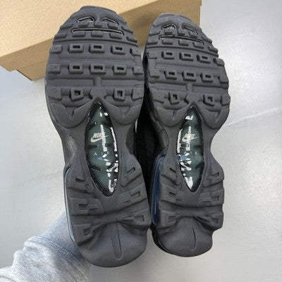 Nike Air Max trainers black and light grey with iconic logo and textured material.