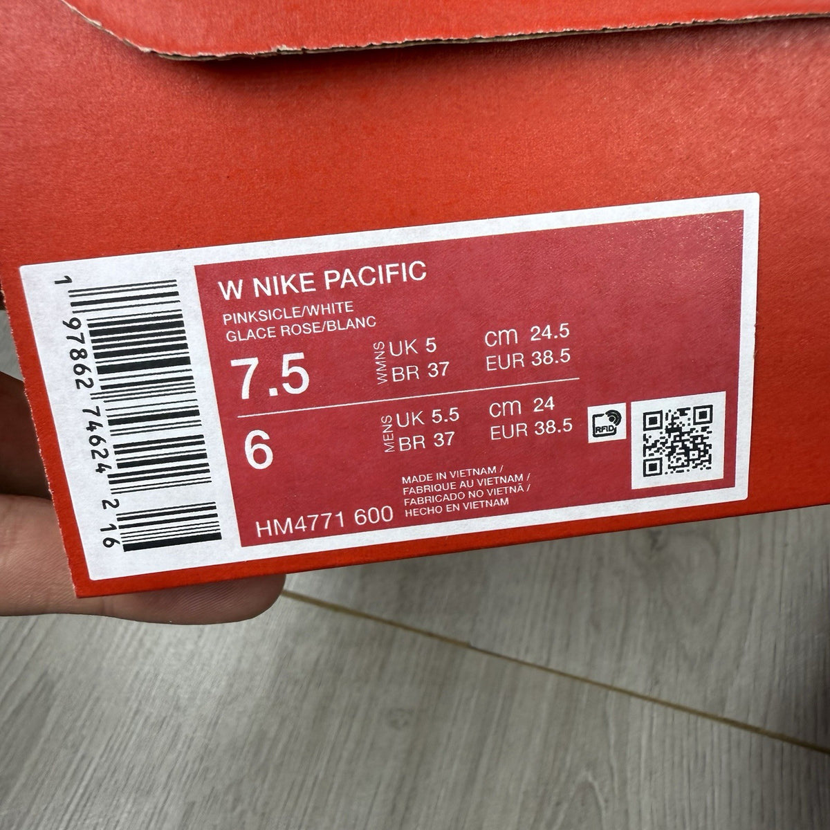 Nike white trainers with pink accents and gum sole, featuring iconic swoosh logo.