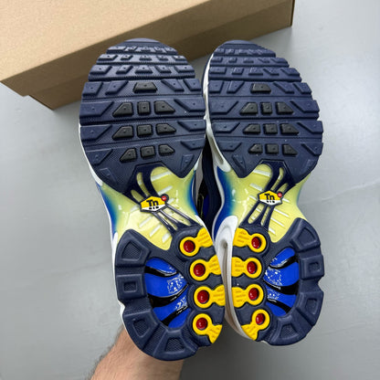 Nike Air Max Plus TN blue trainers with yellow accents and signature swoosh logo.