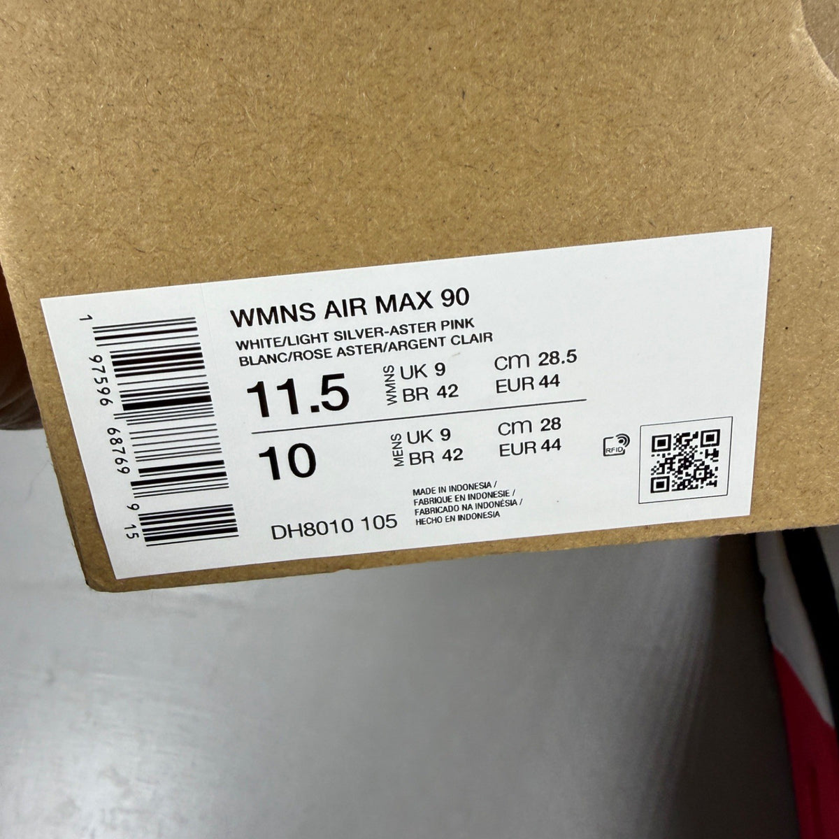 Nike Air Max 90 white trainers with aster pink and black accents, logo on tongue.