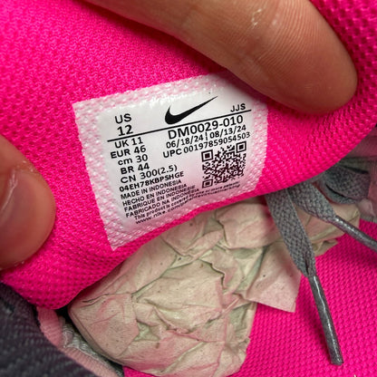 Nike Air Max 90 grey trainers with hyper pink accents and black detailing.