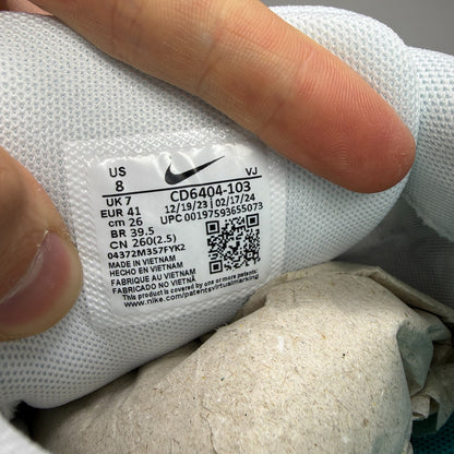 Nike white athletic shoes with dusty cactus accents and mesh upper details.