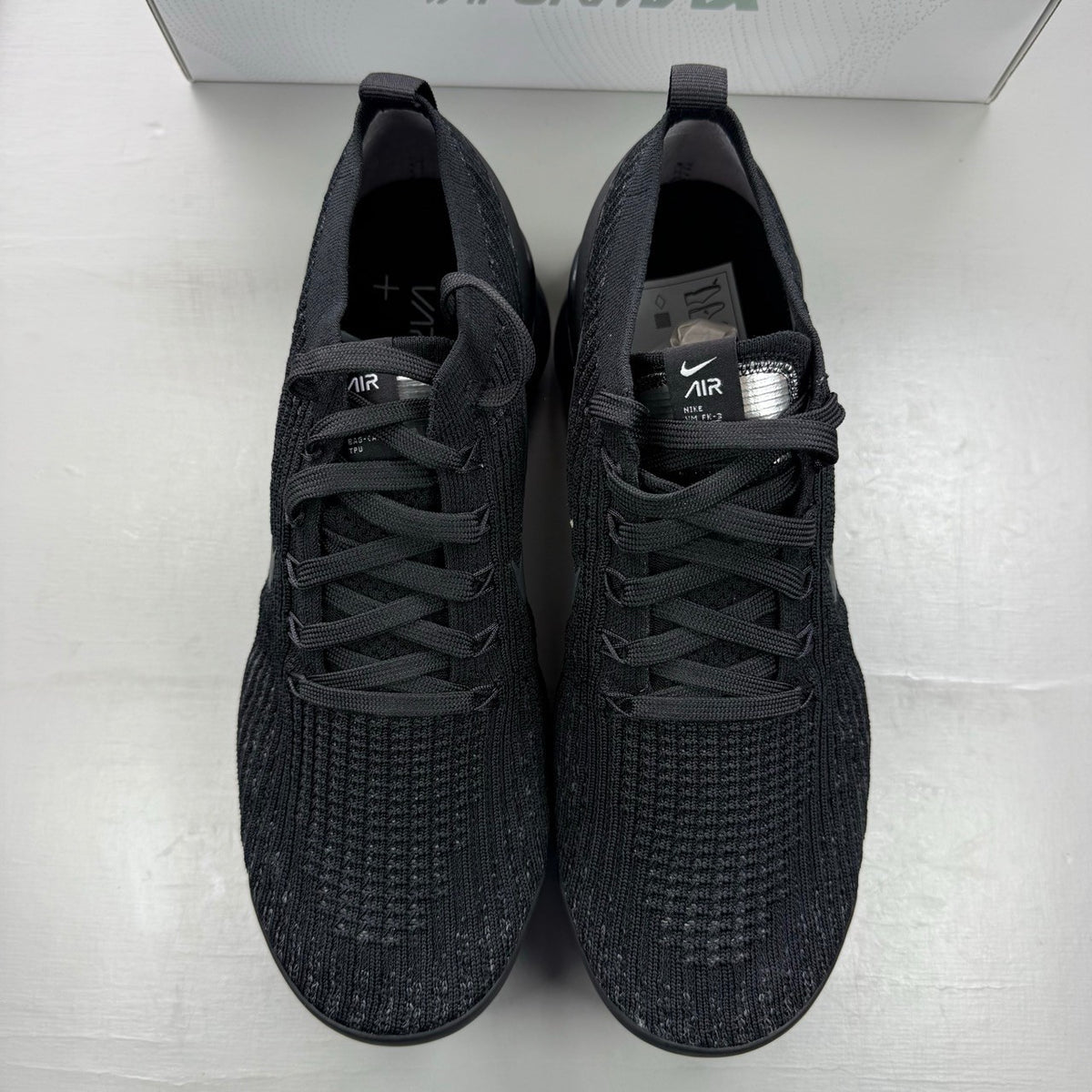 Nike Air VaporMax Flyknit 3 black sneakers with distinctive air cushioning and sleek design.