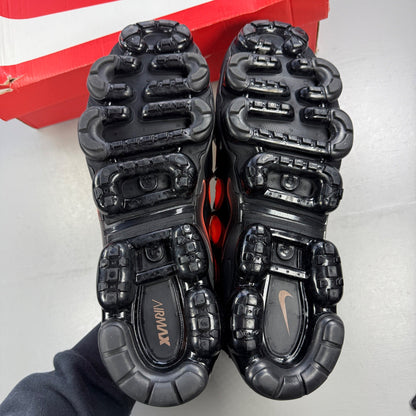 Nike athletic shoes orange with black accents and Air VaporMax sole design.