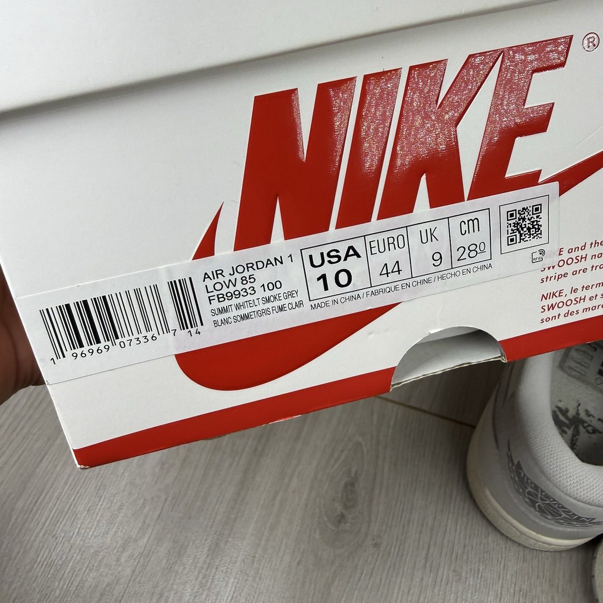 Nike Air Jordan 1 Low 85 grey trainers with white accents and iconic swoosh logo.