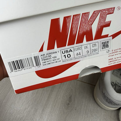 Nike Air Jordan 1 Low 85 grey trainers with white accents and iconic swoosh logo.