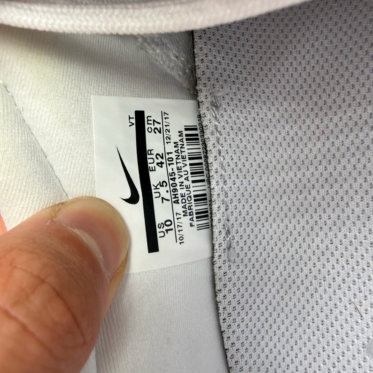 Nike white trainers with gum sole and silver accents, featuring breathable mesh upper.