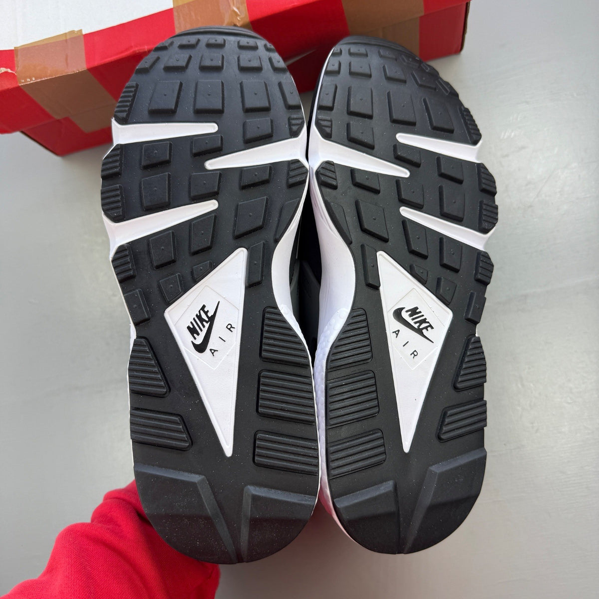 Nike black athletic shoes with safety orange accents and grey detailing.