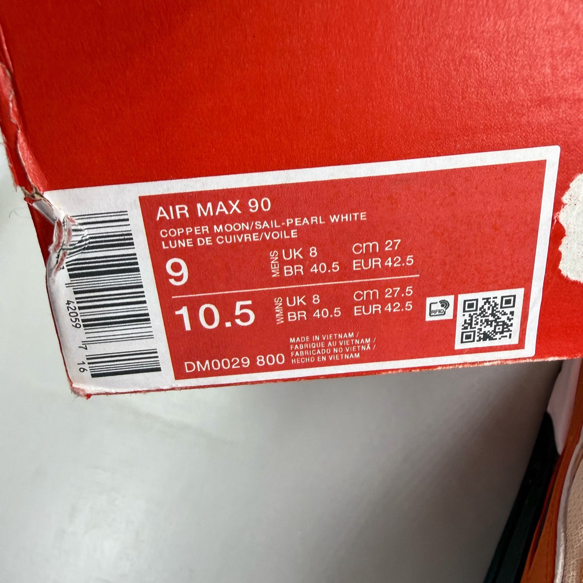Nike Air Max 90 orange trainers with copper accents and signature swoosh logo.