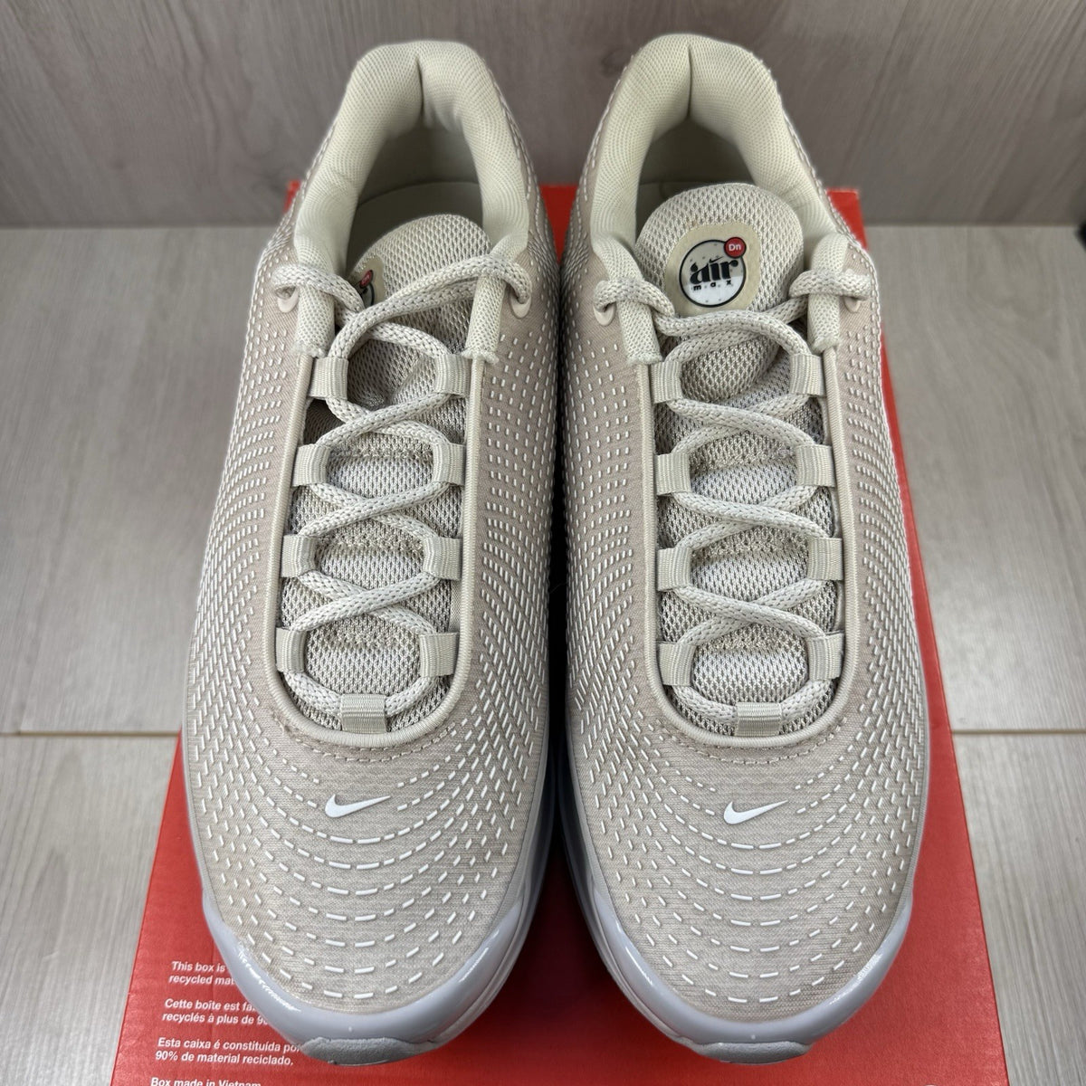 Nike Air Max DN trainers white with light brown accents and logo detail.