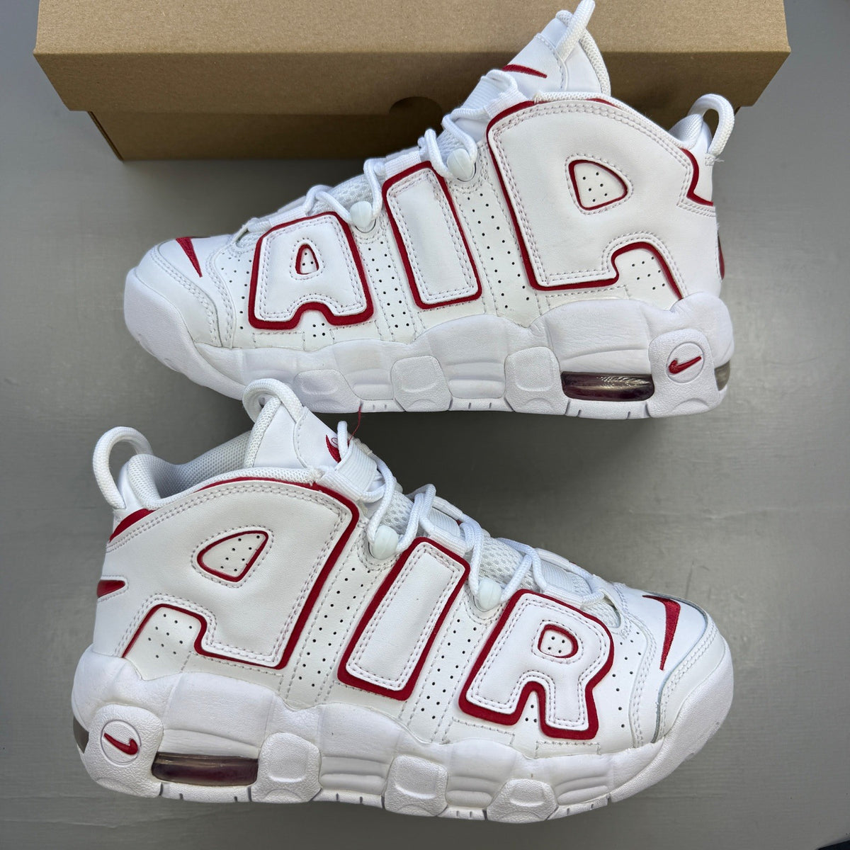 Nike athletic shoes white with varsity red accents and bold "AIR" lettering.