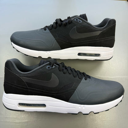 Nike Air Max 1 Ultra 2 black trainers with white accents and sleek design.