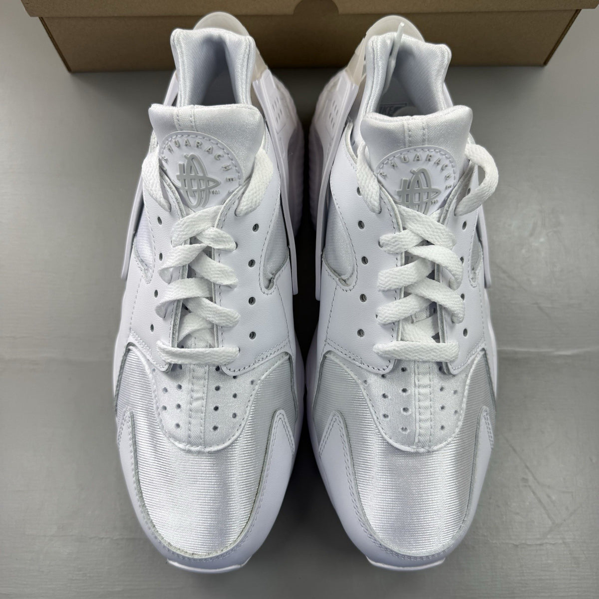 Nike Air Huarache white trainers with Pure Platinum accents and signature logo details.