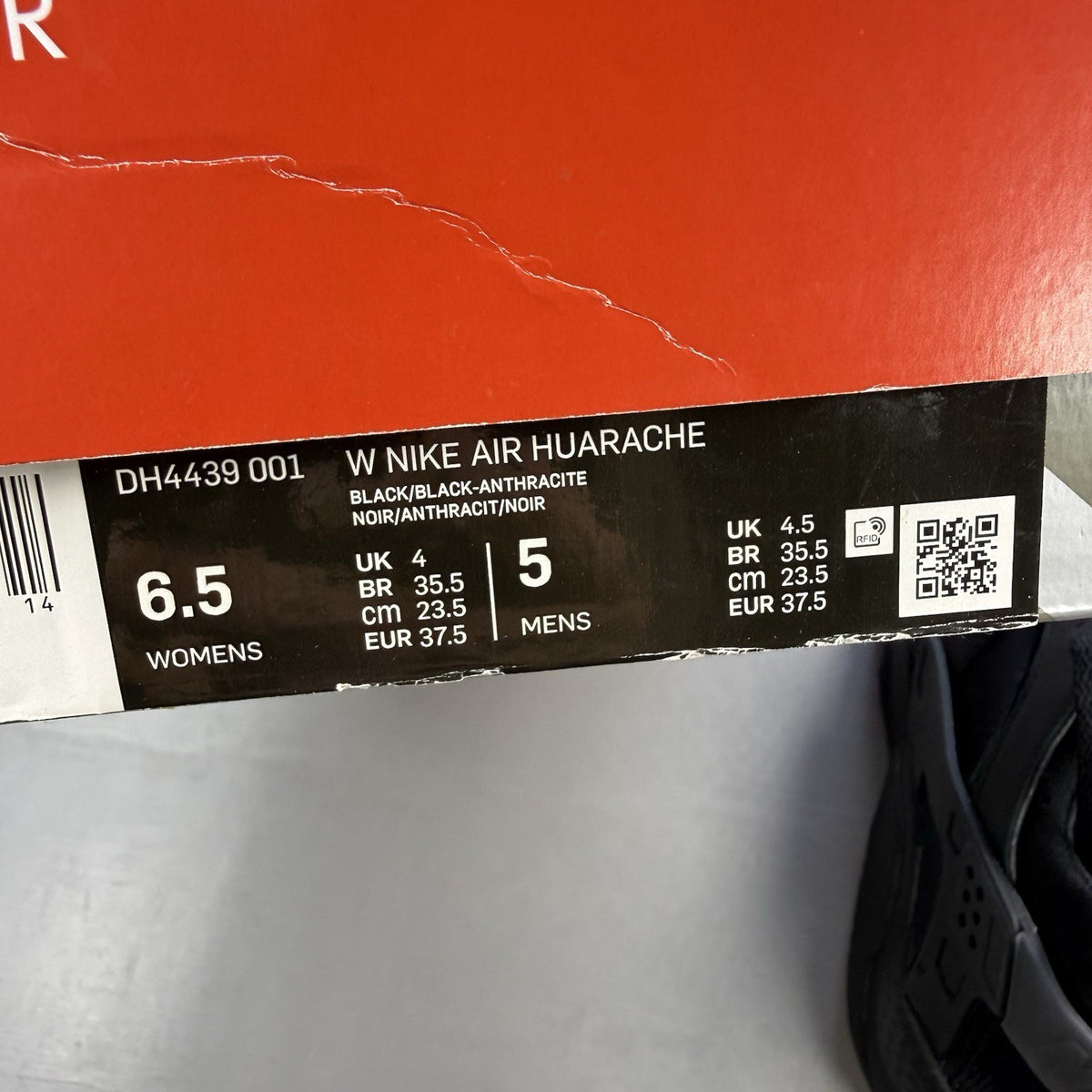 Nike black Air Huarache trainers with anthracite heel tab and distinctive design.