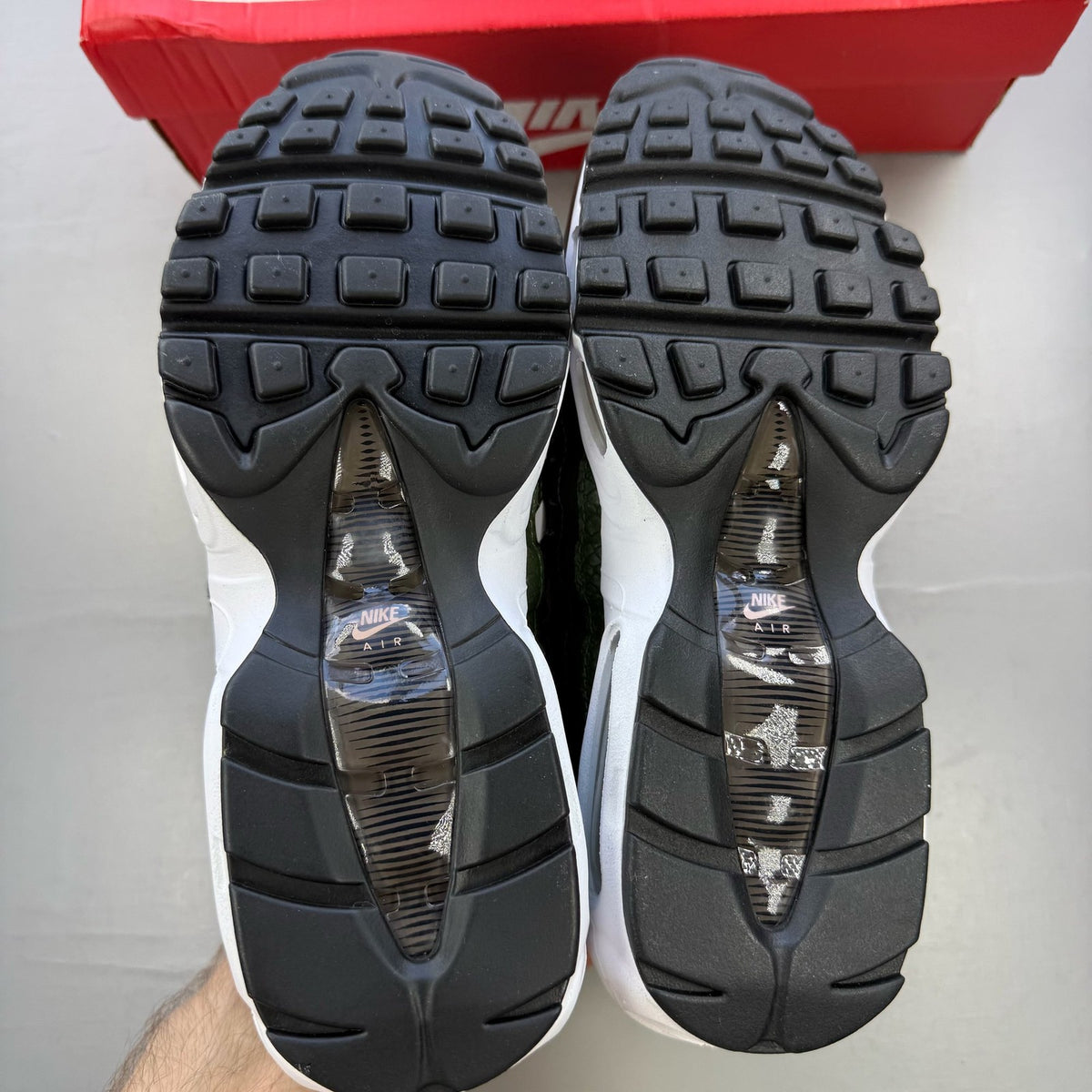 Nike black trainers with pink camo accents and white sole, featuring logo details.