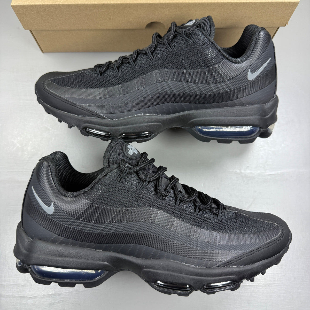 Nike Air Max 95 black trainers with cool grey accents and signature logo details.