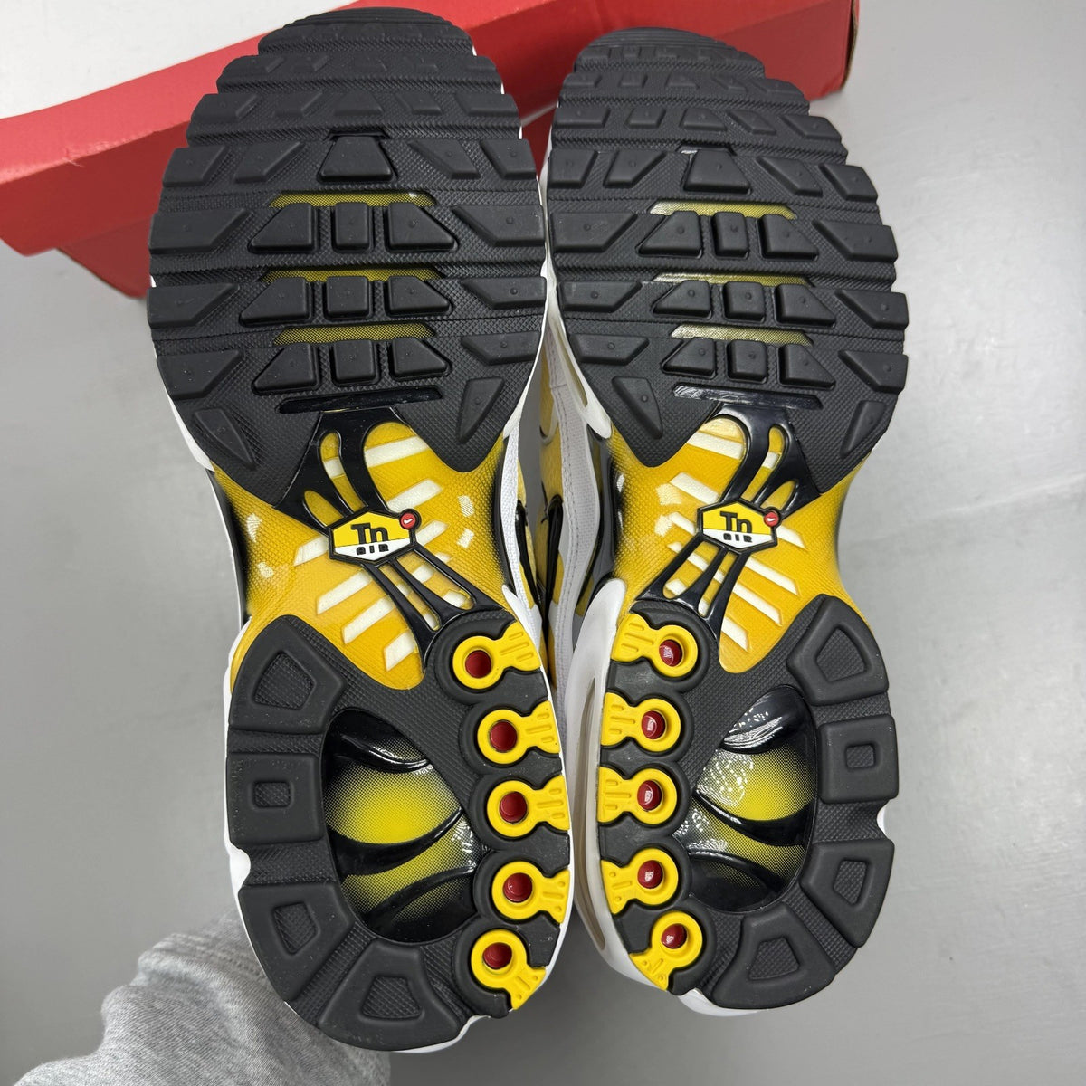 Nike Air Max Plus TN white with varsity maize yellow accents and signature logo.