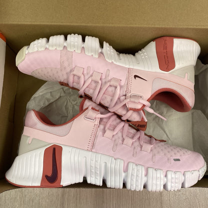 Nike Free Metcon 5 pink foam trainers with white accents and logo detailing.