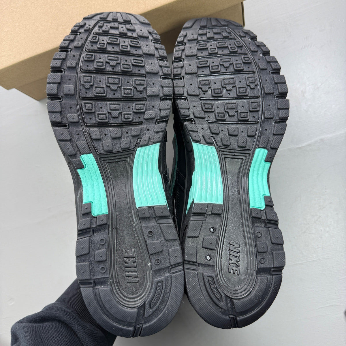 Nike black trainers with grey and turquoise accents, featuring a sleek mesh upper.