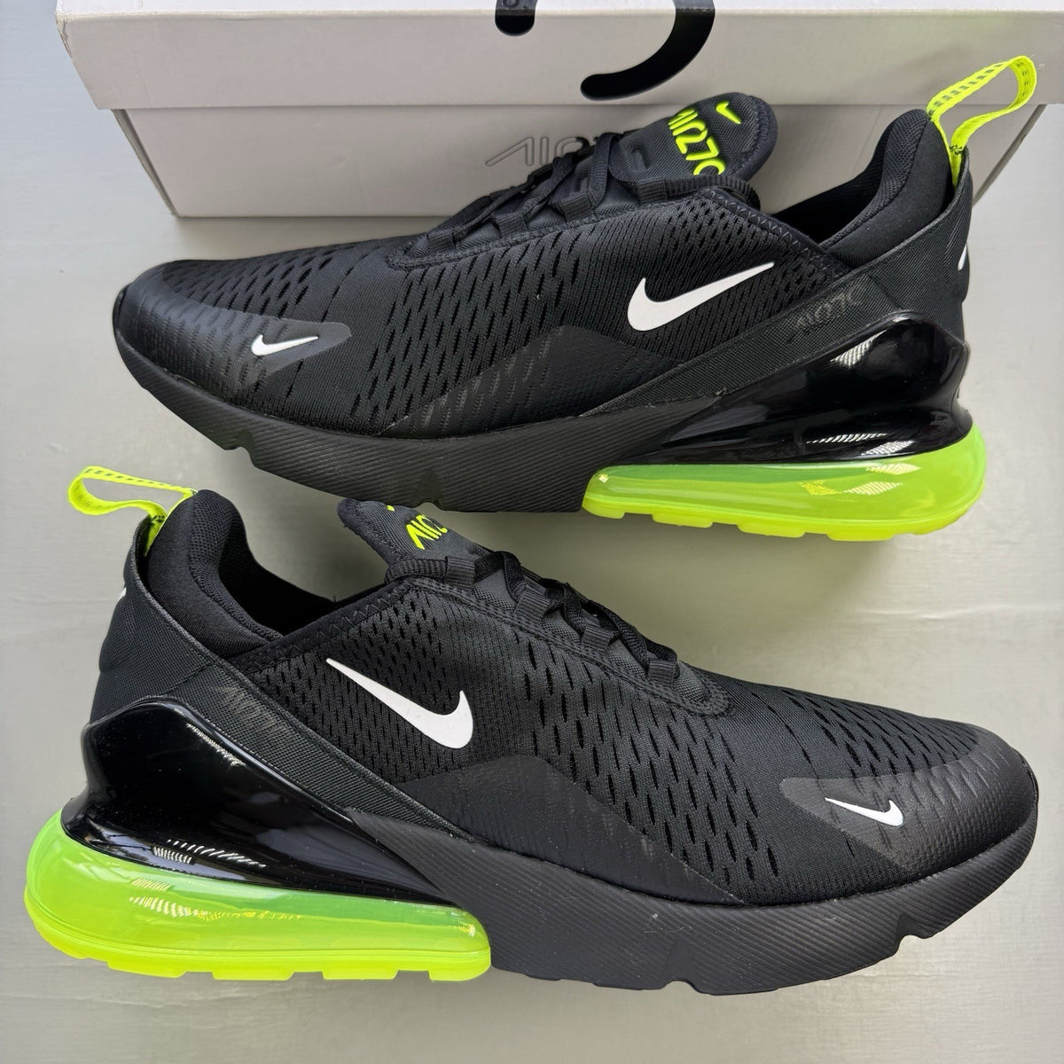 Nike Air Max 270 black trainers with neon volt accents and white sole.