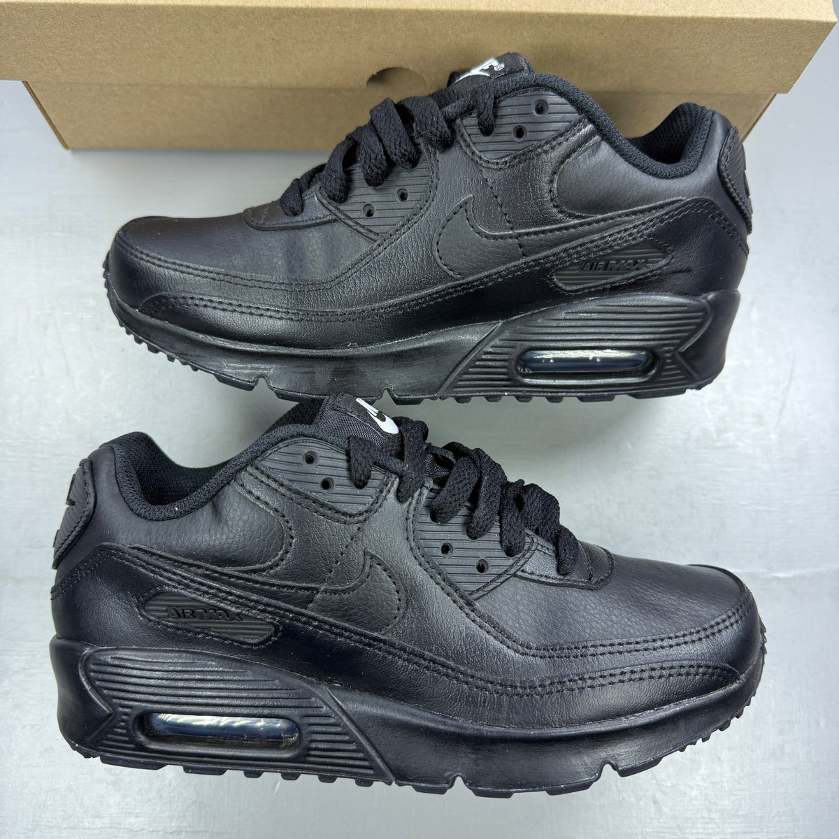 Nike black athletic shoes leather with Air Max logo and triple black design.