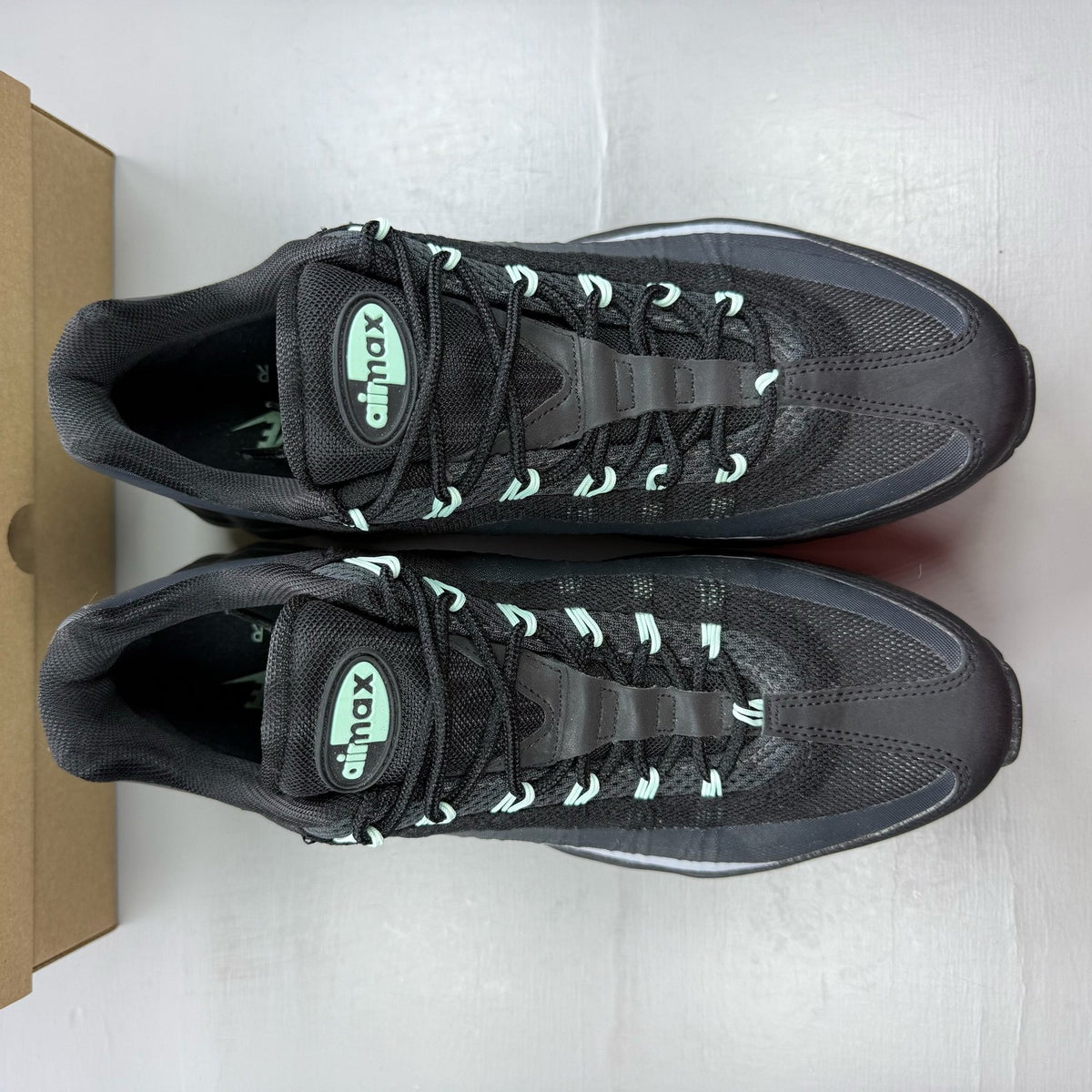 Nike Air Max 95 black trainers with mint foam accents and anthracite detailing.