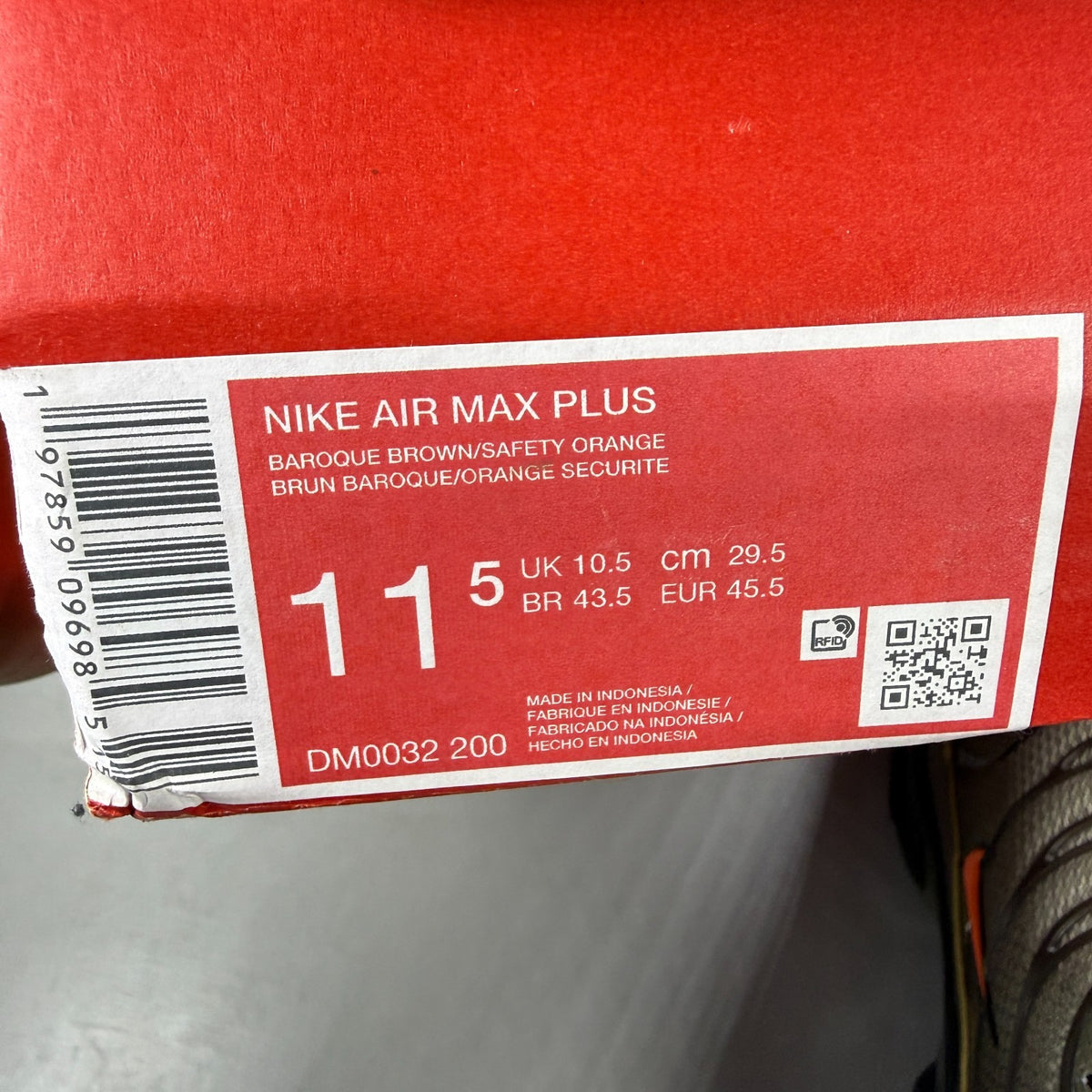Nike Air Max Plus TN brown athletic shoes with safety orange accents and logo details.