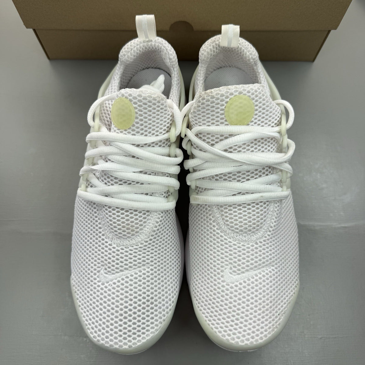 Nike Air Presto white trainers with black accents and mesh upper.