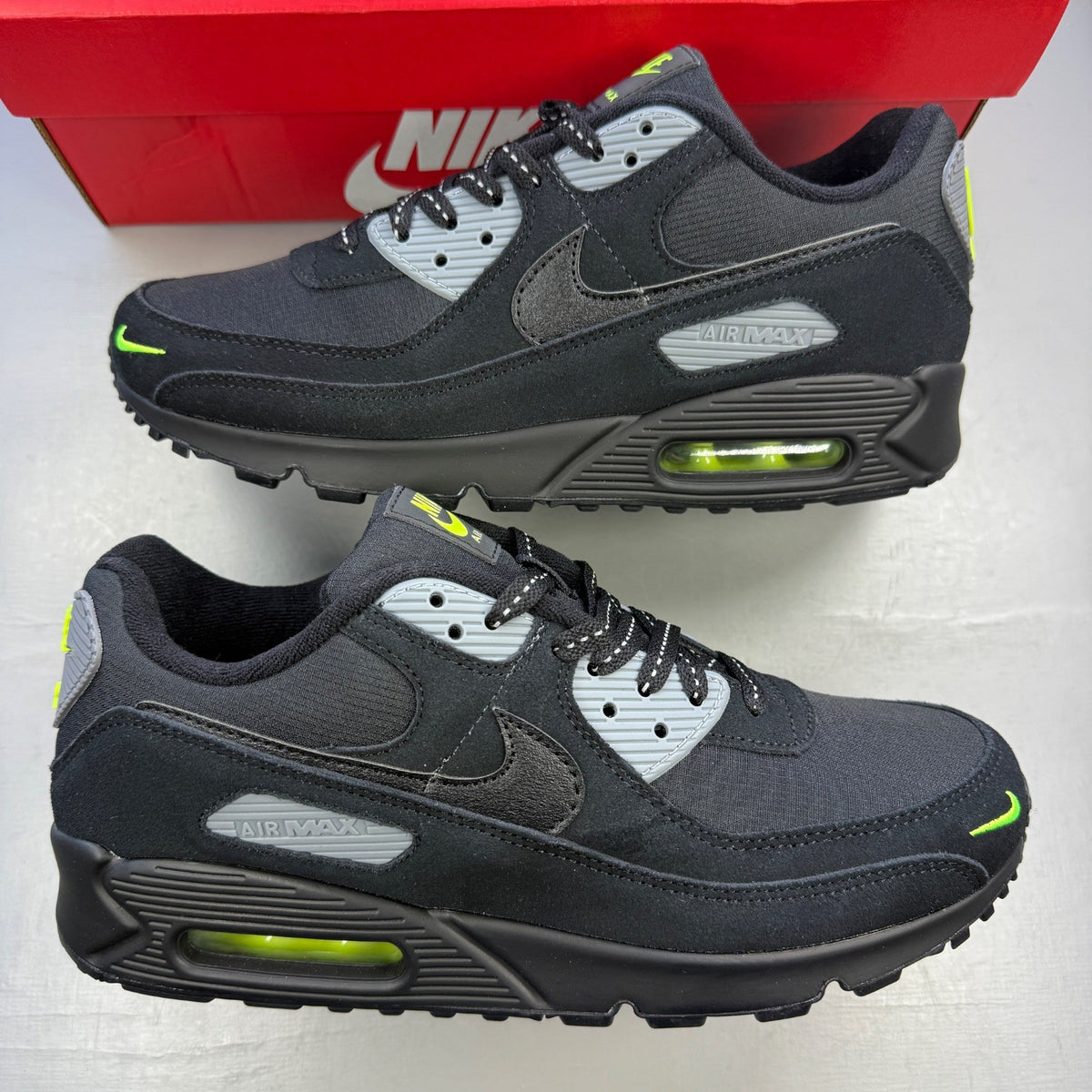 Nike Air Max 90 black with volt accents and mini swoosh logo, brand new condition.