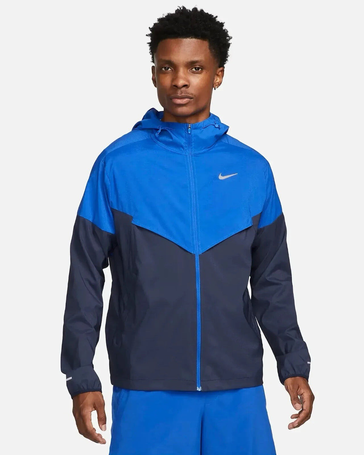 Nike blue Windrunner jacket with logo detail and water-repellent material.