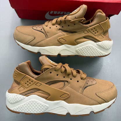 Nike brown trainers with gum sole and white accents, featuring iconic Huarache design.