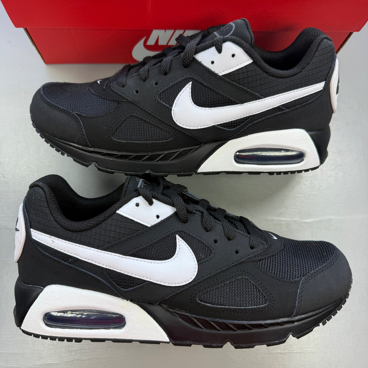 Nike running shoes black and white, featuring classic logo and sleek design.