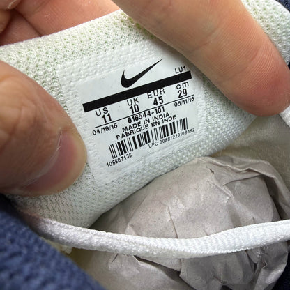 Nike white running trainers with black and navy accents, featuring logo details.
