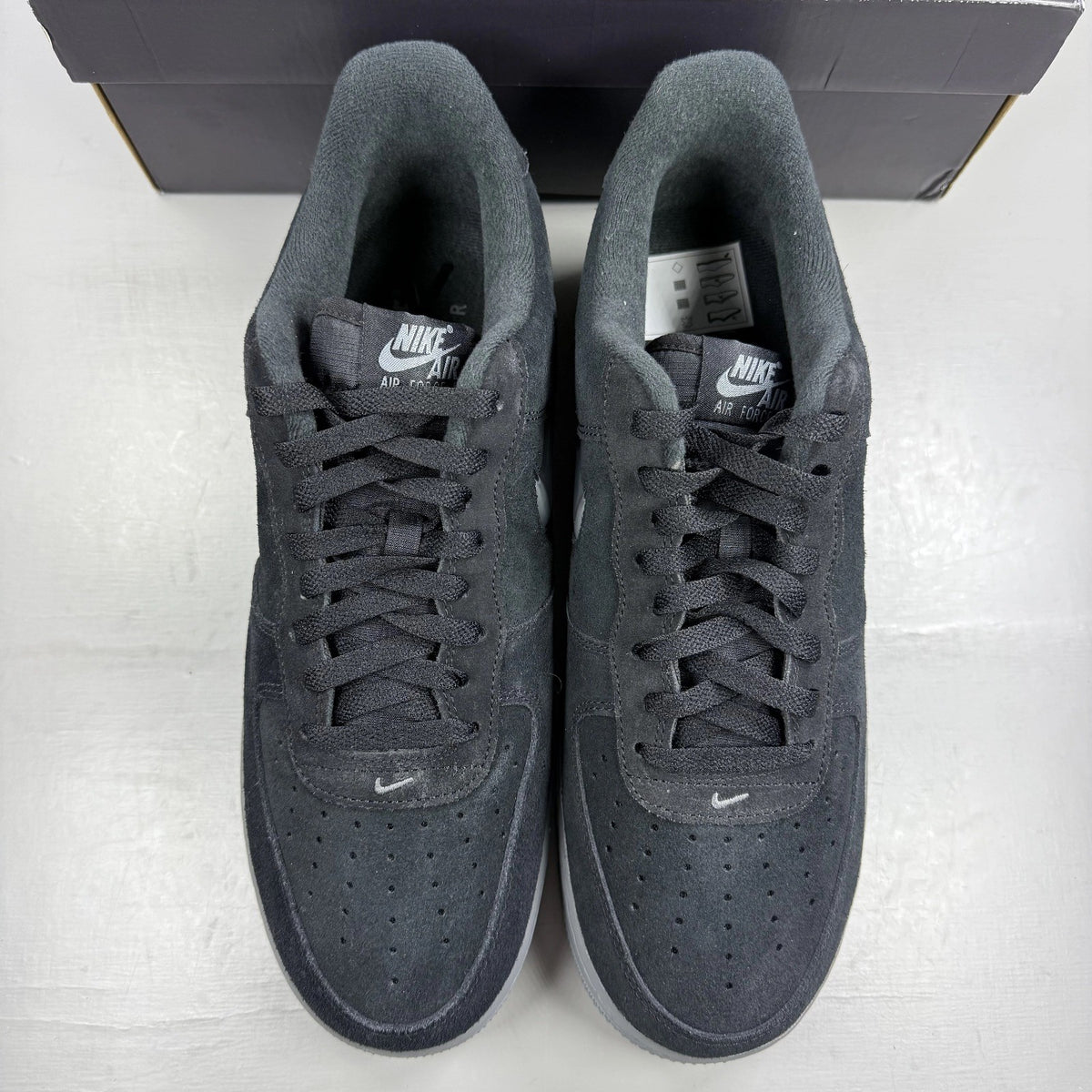 Nike Air Force 1 black trainers with cool grey accents and jewel detailing.