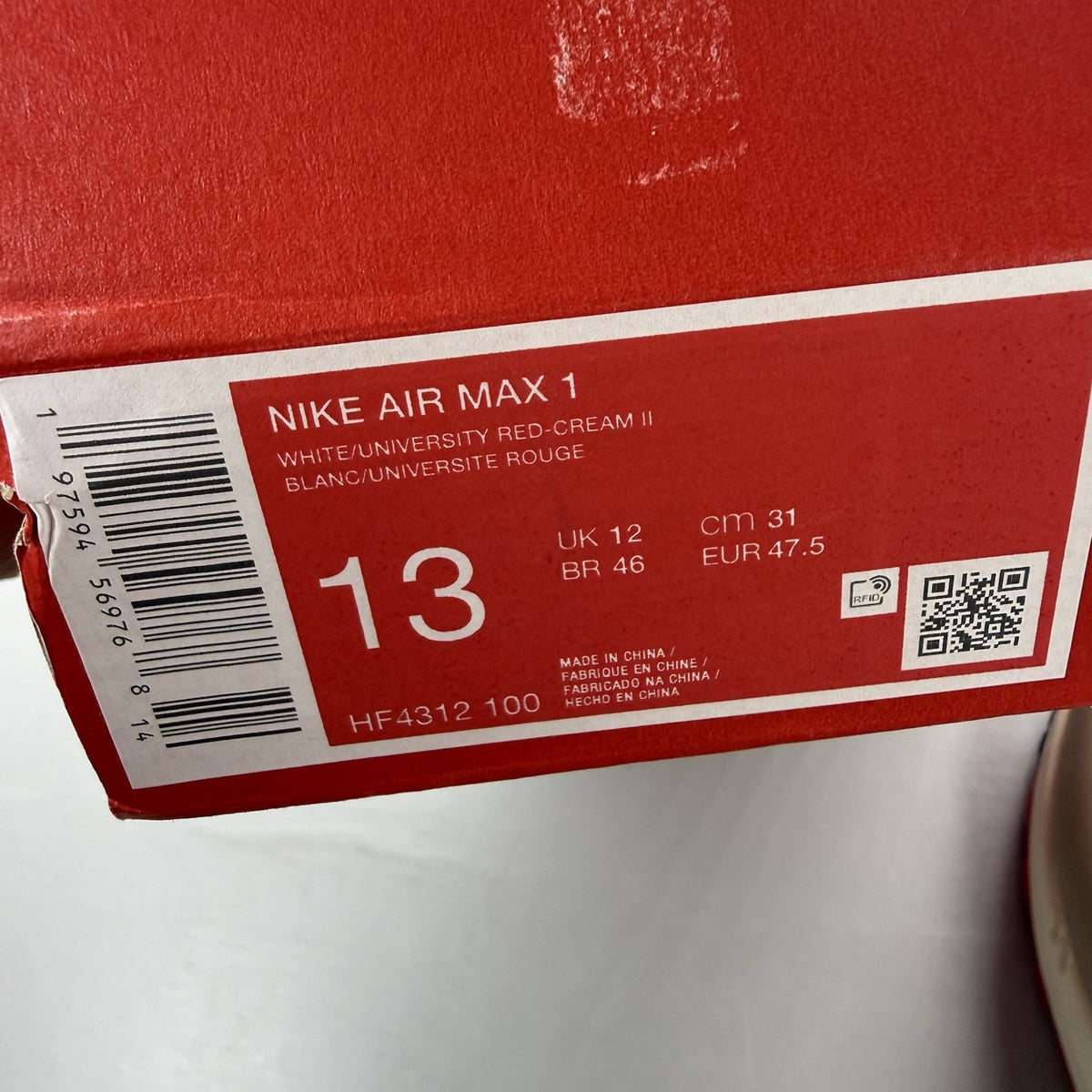 Nike Air Max 1 trainers white with university red accents and cream detailing.