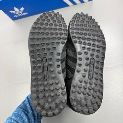 Adidas black deck shoes with three stripes logo and textured upper.