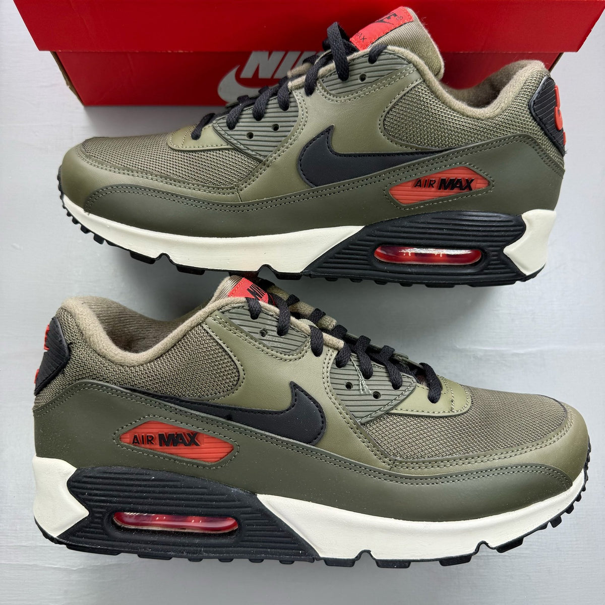 Nike Air Max 90 green trainers with black accents and classic logo detail.