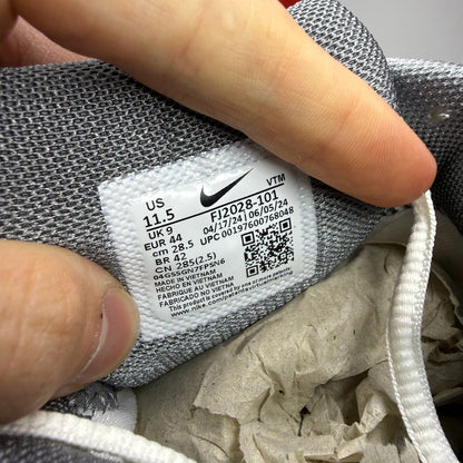 Nike Zoom Vomero 5 white trainers with grey accents and logo detailing.