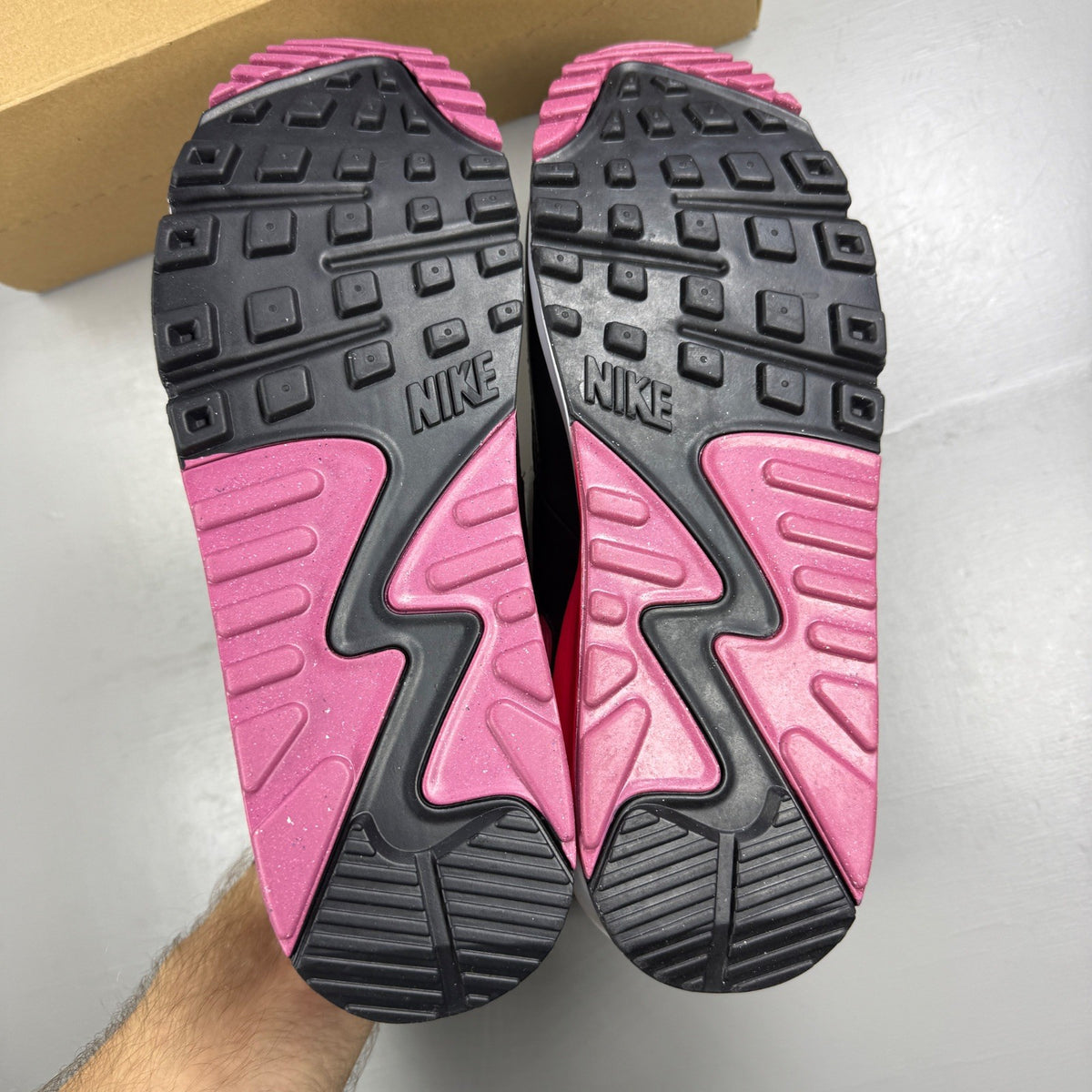 Nike Air Max 90 white trainers with aster pink and black accents, logo on tongue.