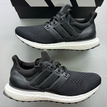 Adidas Ultraboost 1.0 black trainers with white accents and signature three-stripe logo.