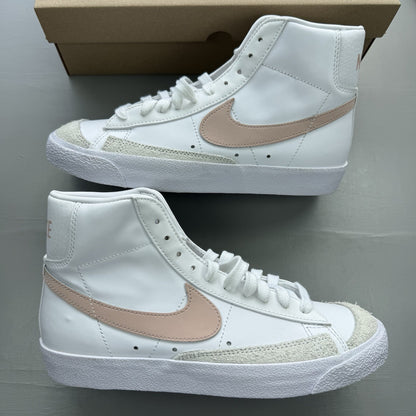 Nike Blazer Mid 77 white trainers with pink accents and retro logo design.