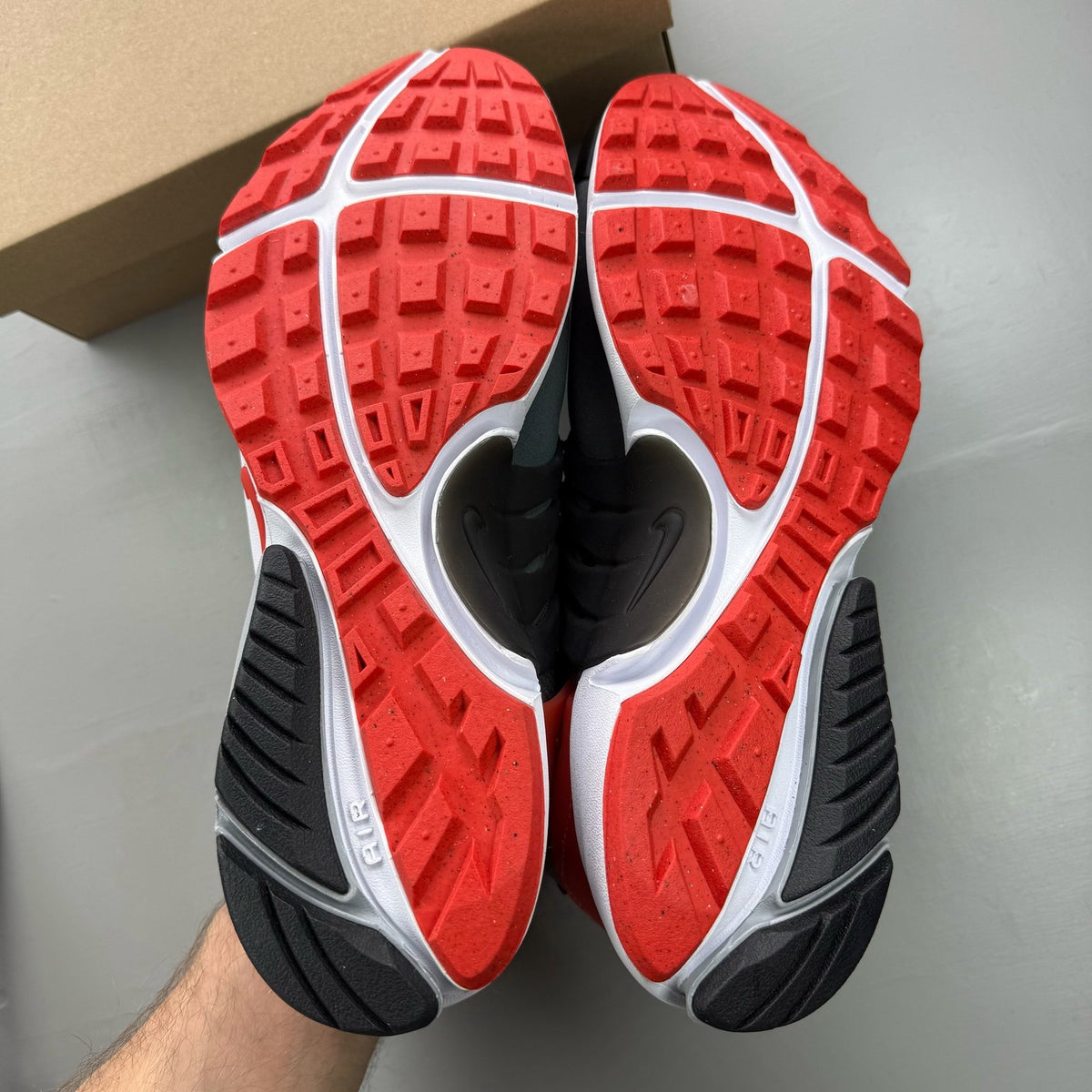 Nike Air Presto grey trainers with black and red accents, featuring a sleek design.