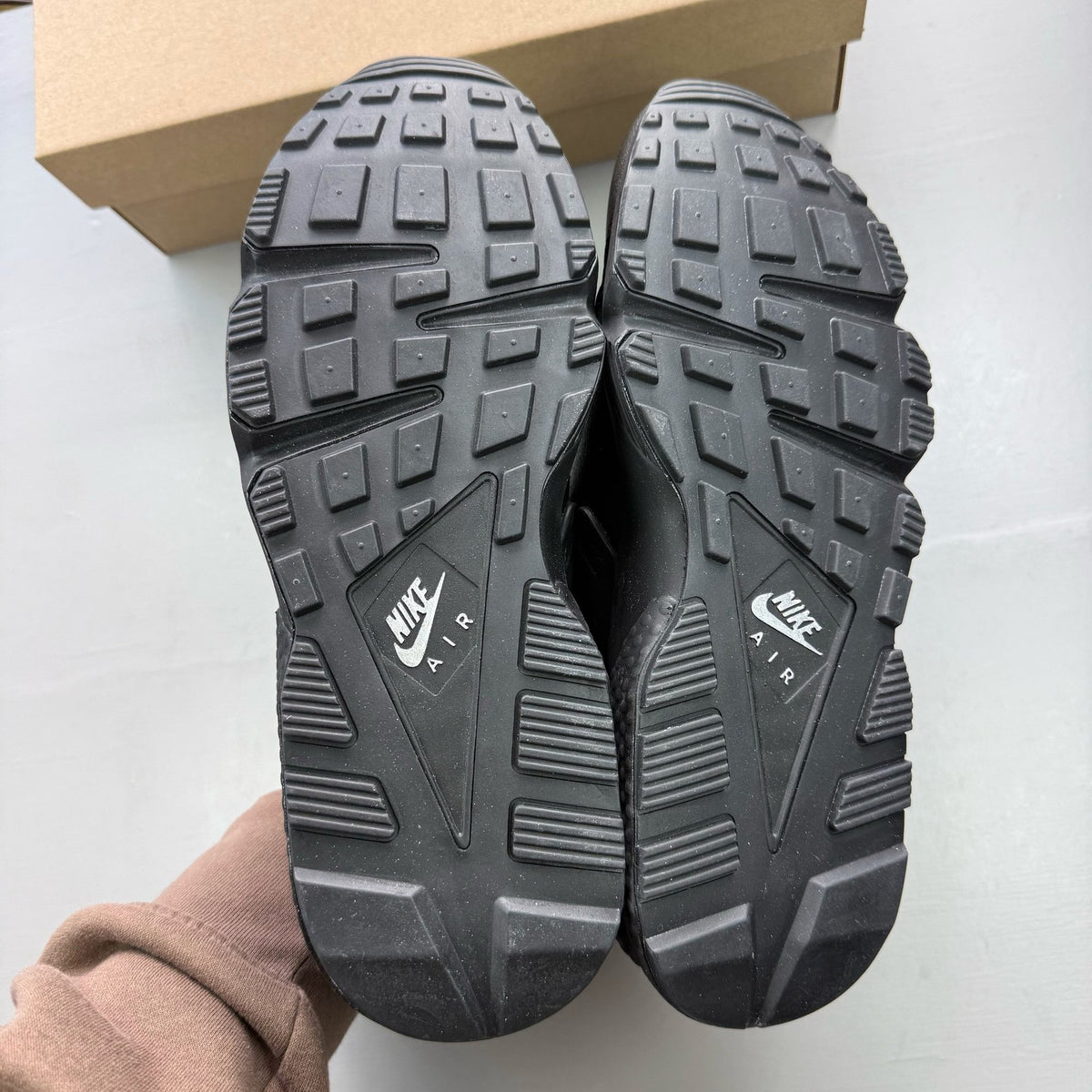 Nike black Air Huarache trainers with metallic silver mini swoosh logo.