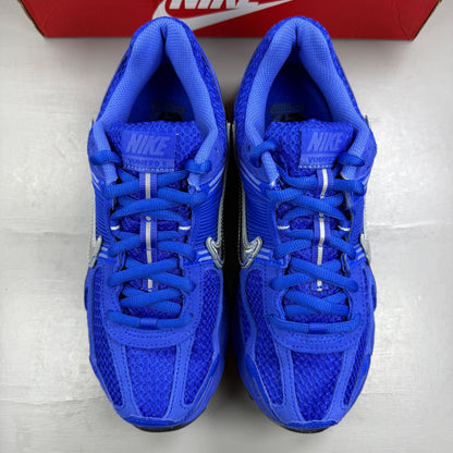 Nike Zoom Vomero 5 blue trainers with silver accents and logo detailing.