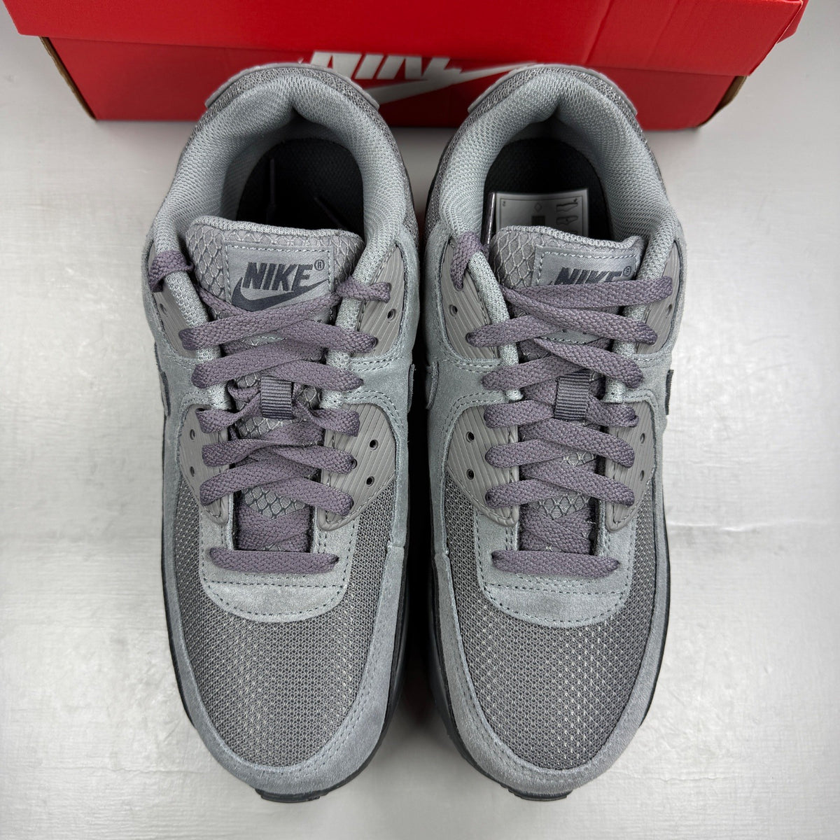 Nike Air Max 90 Tech grey trainers with blue accents and logo detail.