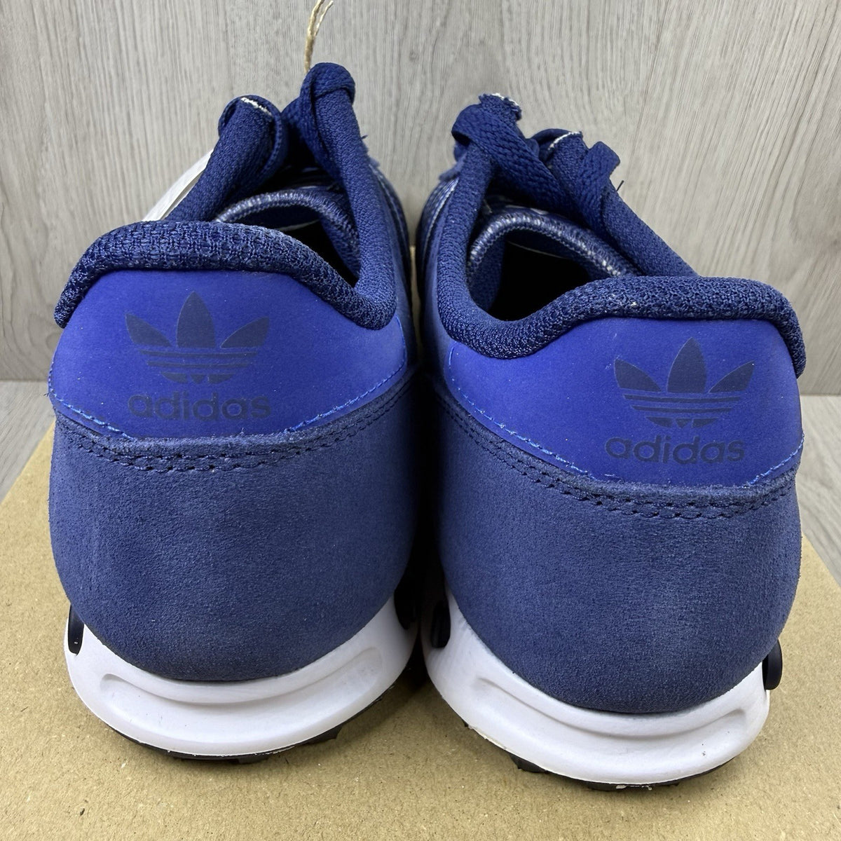 Adidas blue LA Trainers with white stripes and logo detailing on the side.