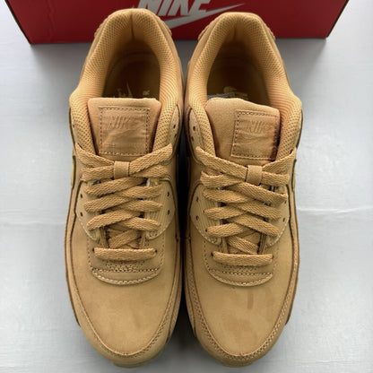 Nike Air Max 90 Premium beige trainers with gum sole and subtle branding details.