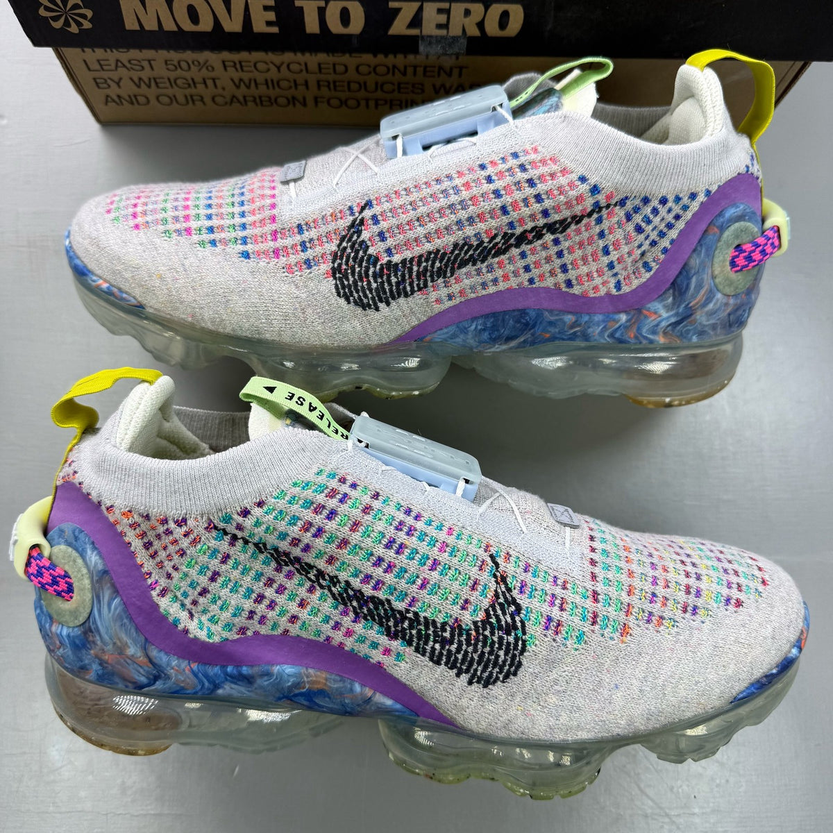 Nike multicolor Flyknit trainers in grey with distinctive air cushioning and logo detail.