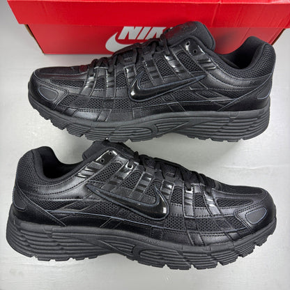 Nike black trainers with mesh upper, reflective detailing, and padded collar.