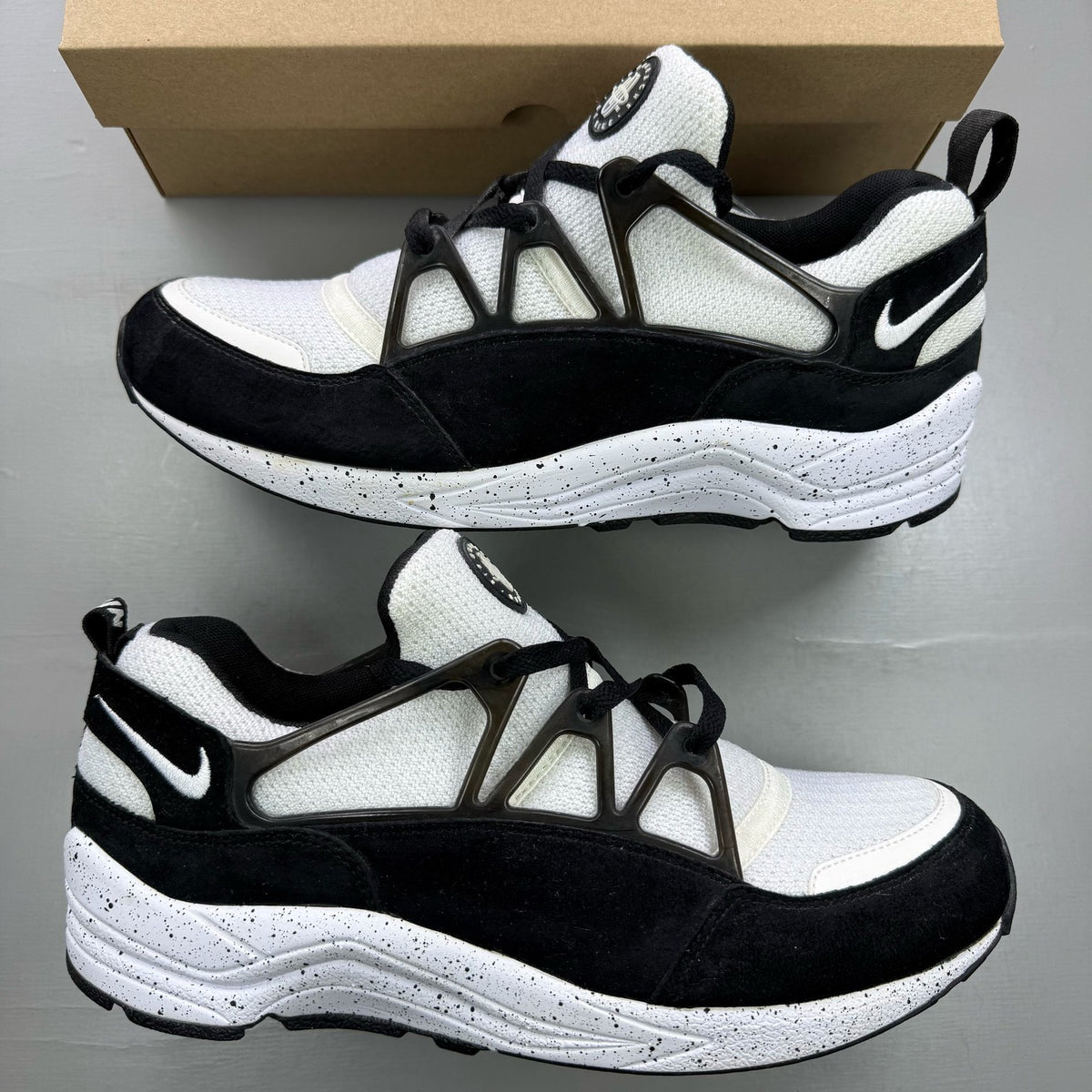 Nike black Air Huarache Light trainers with white accents and mesh detailing.